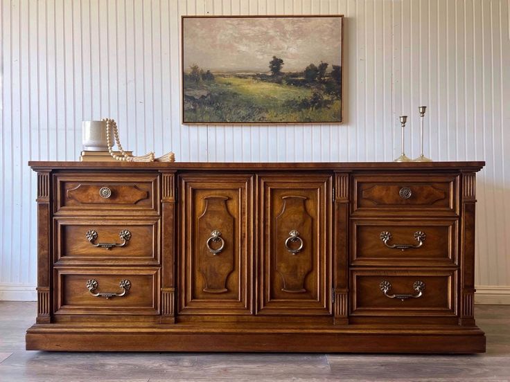 a large wooden dresser sitting next to a painting