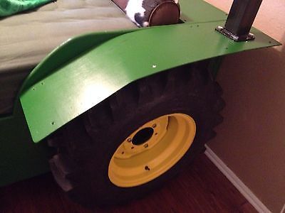 a child's bed made to look like a tractor