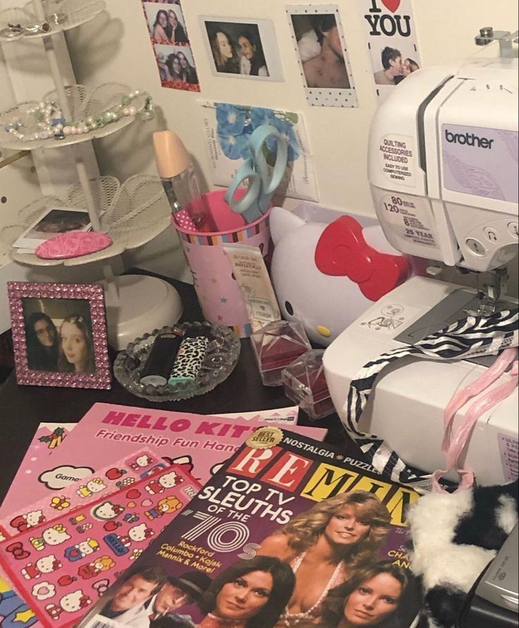 a sewing machine sitting on top of a table next to magazines and other items in front of it