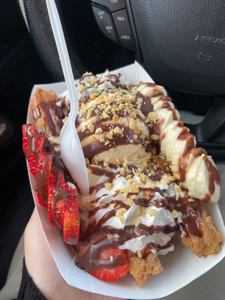 a person holding a plate with some kind of food on it and a fork sticking out of it