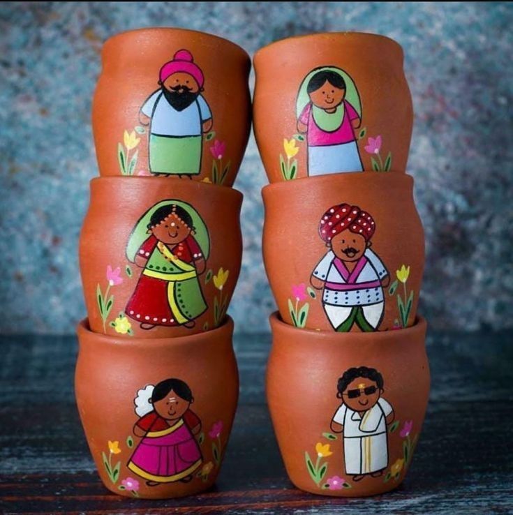 four clay pots painted with people on them