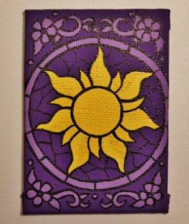 a purple and yellow tile with a sun design on it's side, hanging from the wall