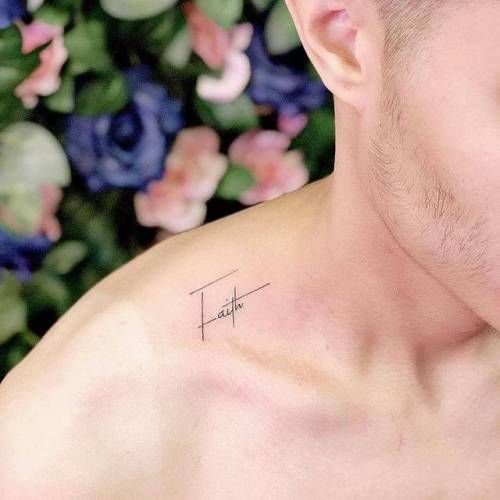 a man with a small tattoo on his chest next to some blue and pink flowers