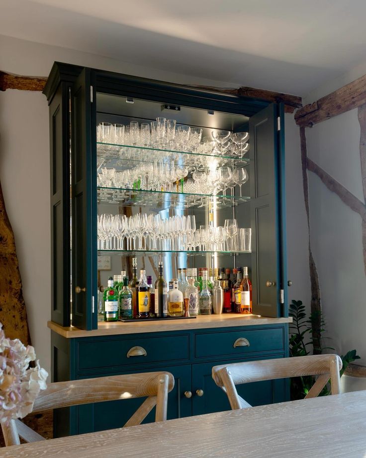 a bar with wine glasses and liquor bottles on the top shelf in front of it