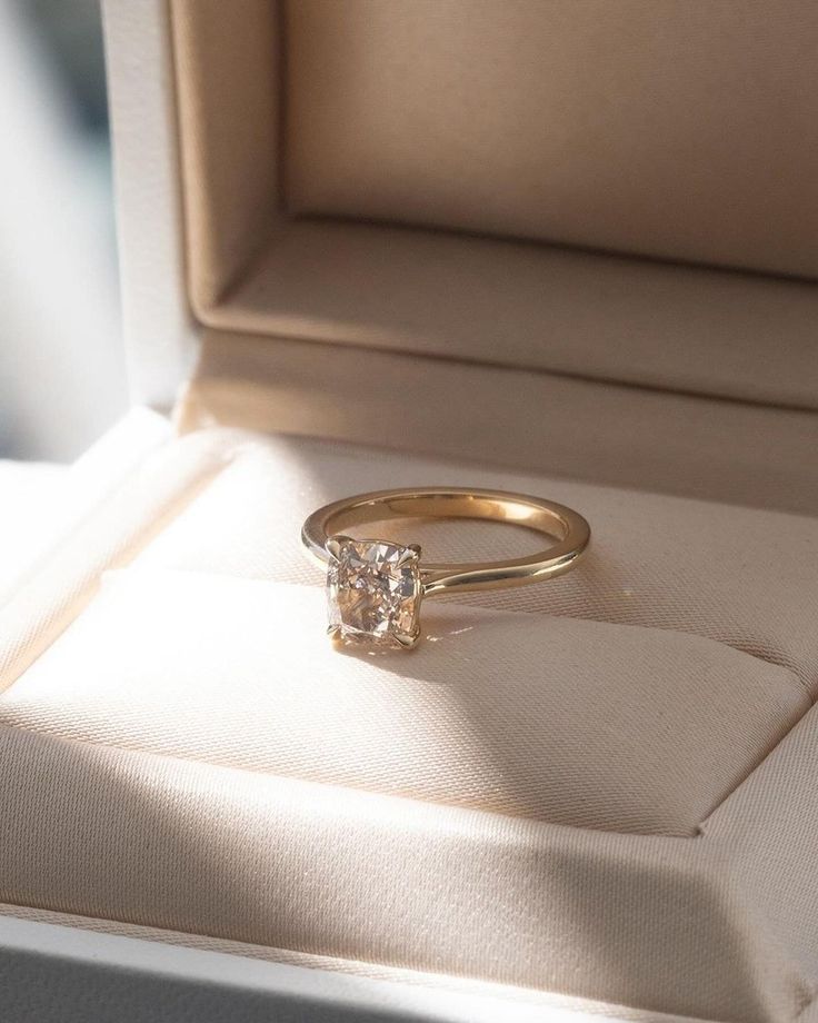 an engagement ring in a box with the lid open to show it's diamond