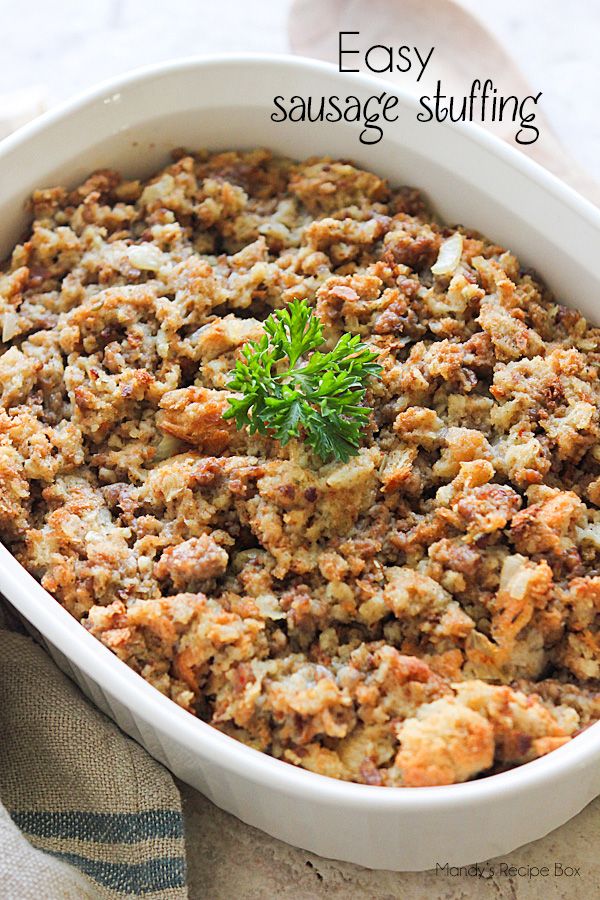 a casserole dish filled with sausage stuffing and topped with a green sprig