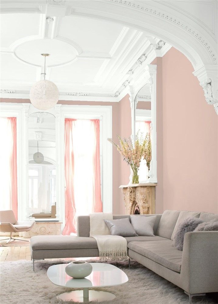 a living room filled with furniture and pink walls