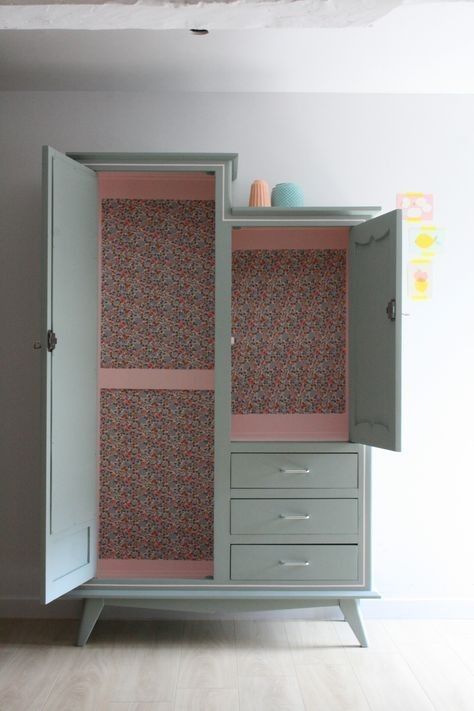 an armoire with floral wallpaper and drawers