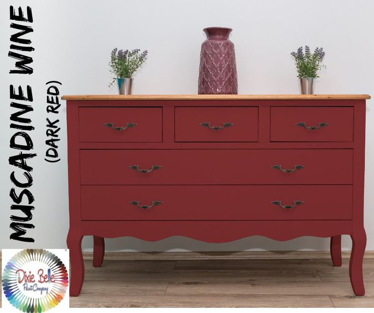 a red dresser with two vases on top of it