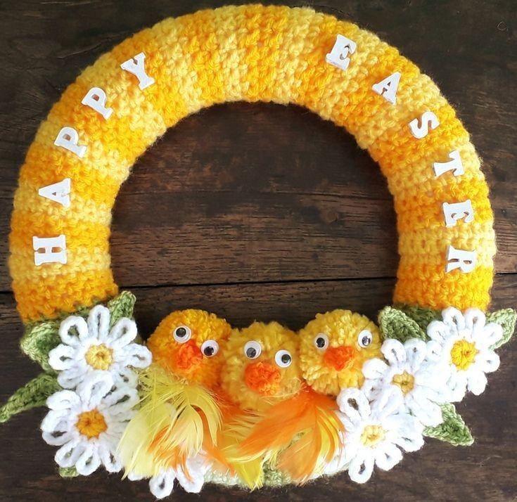 a crocheted wreath with two birds and daisies on it, says happy birthday