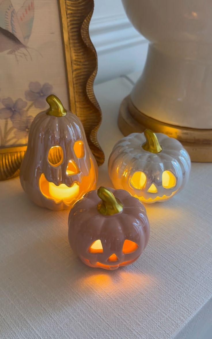 three lighted pumpkins sitting on top of a table