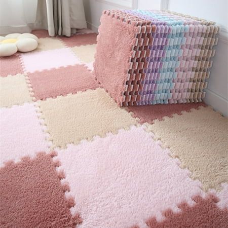 an area rug with pink, blue, yellow and white squares on it in front of a window