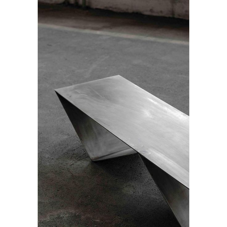 a metal bench sitting on top of a cement floor