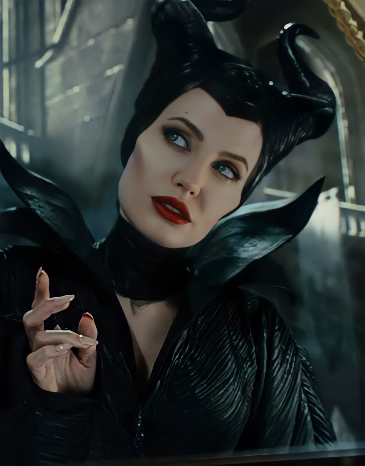 the maleficent character is dressed in black with horns on her head and hands