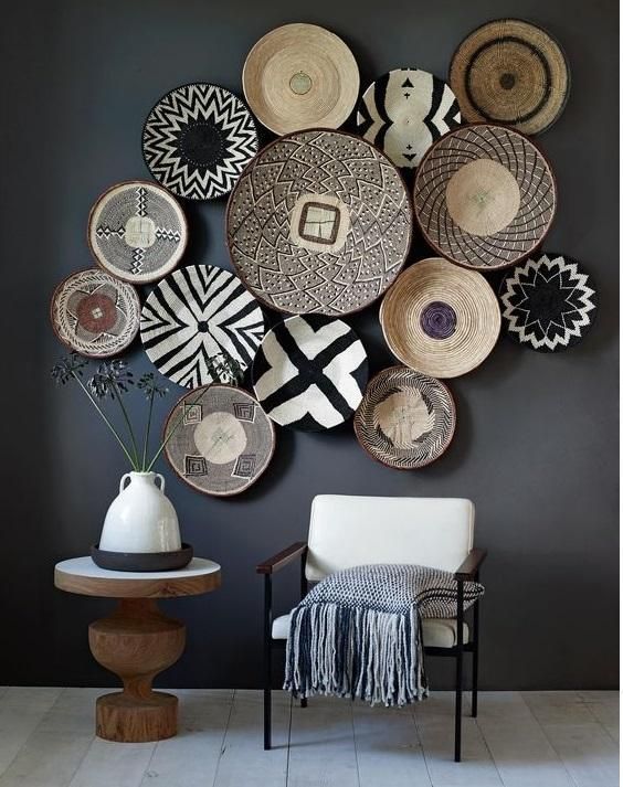 a room with some baskets on the wall and a chair in front of it next to a table