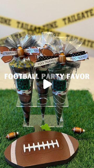 two football party favors in plastic wrappers on green grass