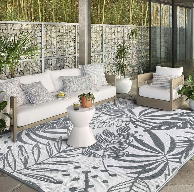 an outdoor living area with white furniture and plants