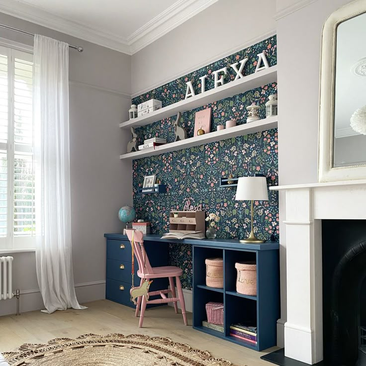 a living room filled with furniture and a fire place in front of a wallpapered wall