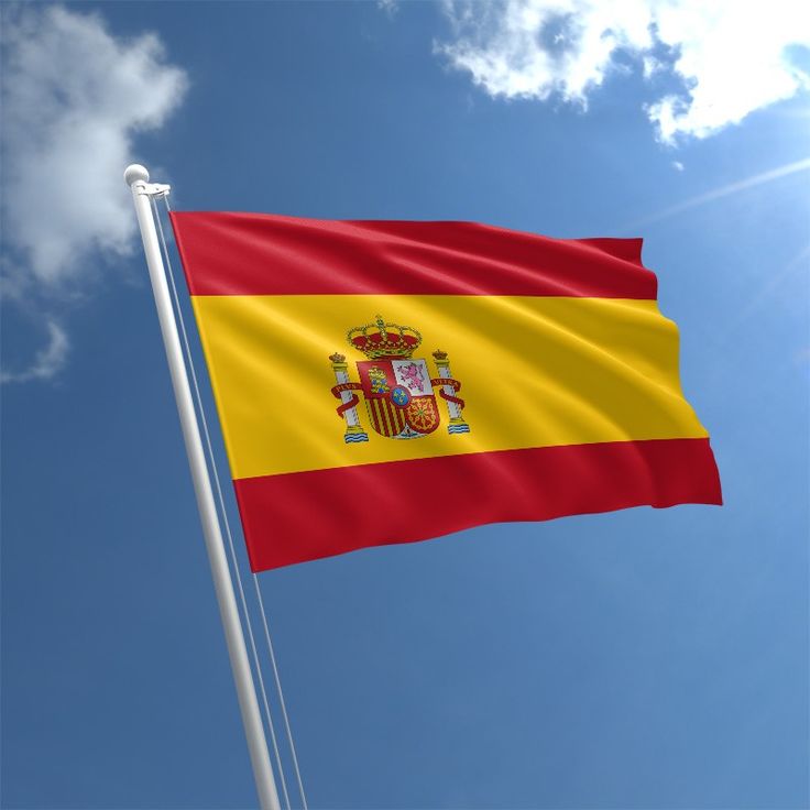 the flag of spain is flying high in the blue sky with white clouds behind it