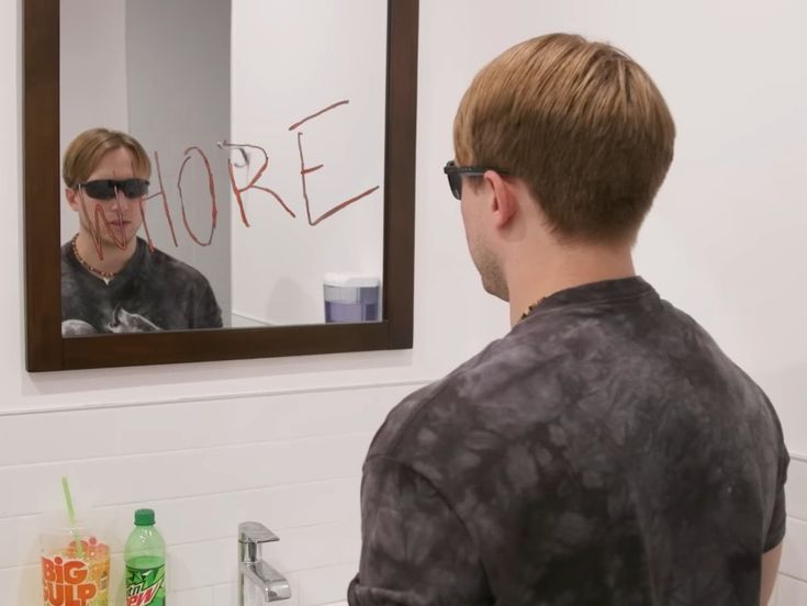 a man is looking at himself in the mirror