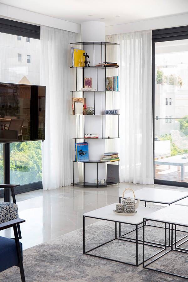 a living room filled with furniture and a flat screen tv sitting on top of a wooden shelf