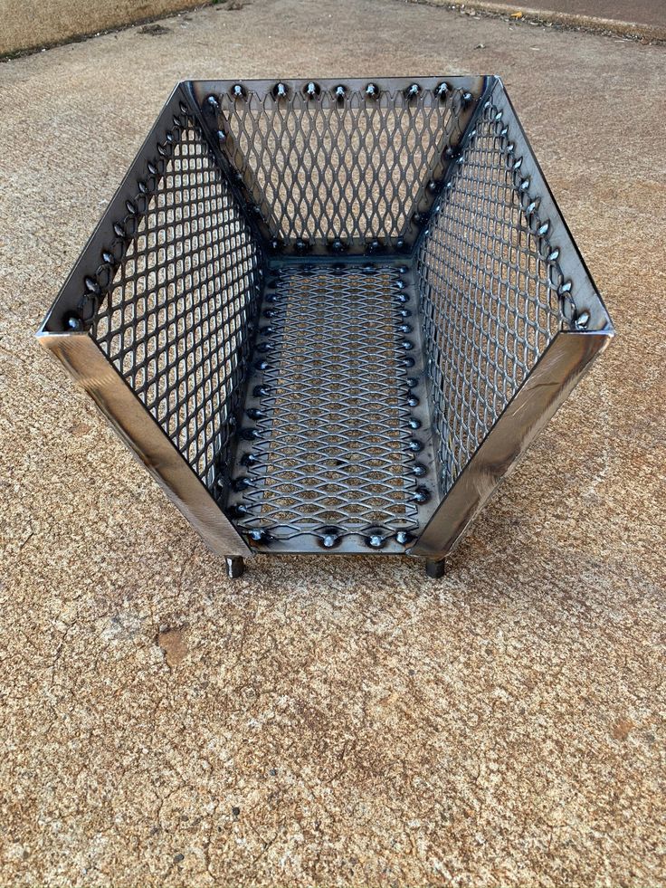 a metal basket sitting on the ground