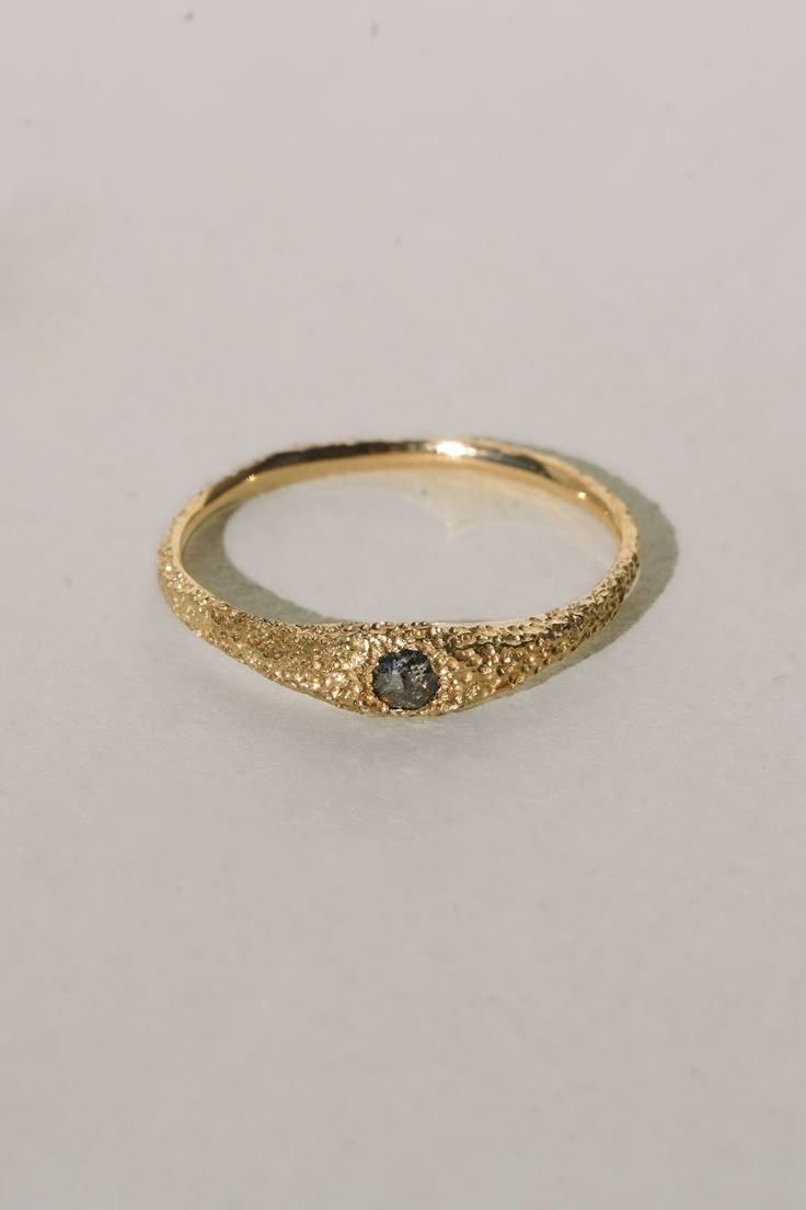 a gold ring with a black diamond on it