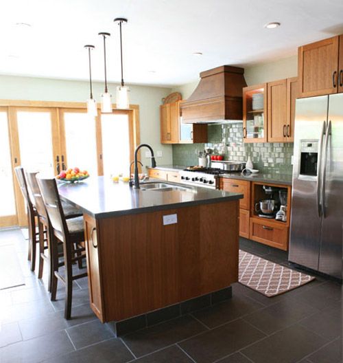 a large kitchen with stainless steel appliances and wooden cabinetry, along with an island in the middle