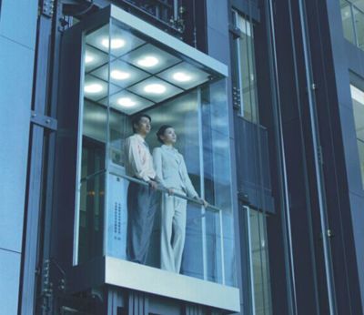 two people standing on a balcony in front of a tall building with glass balconies