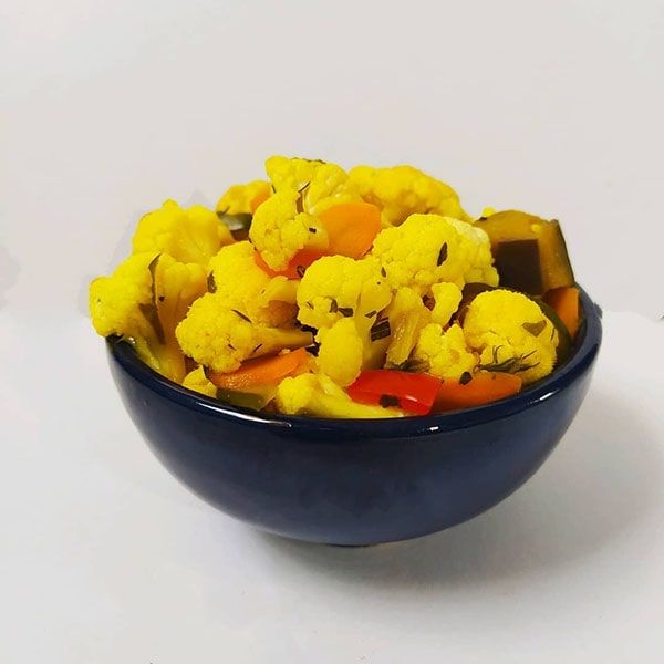 a bowl filled with cauliflower and carrots on top of a white table