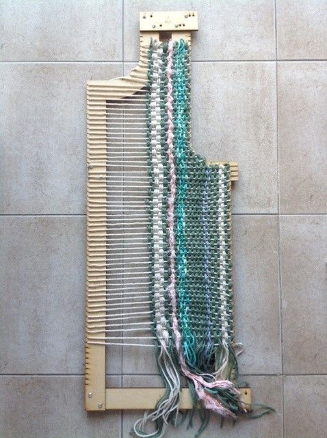 a close up of a weaving machine on a tile floor next to a tiled wall