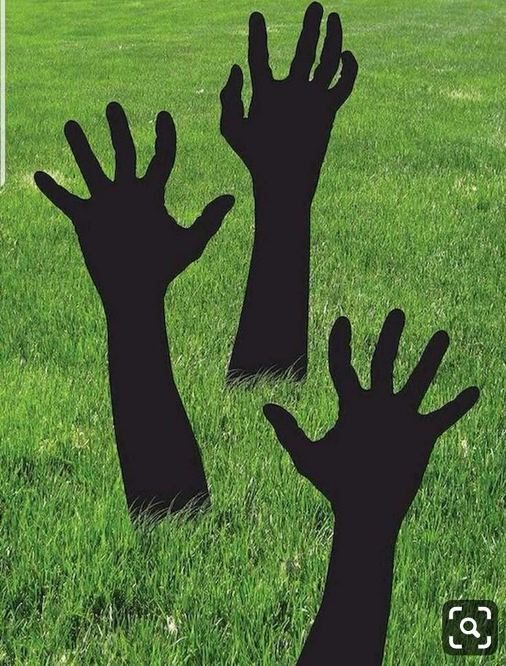 two silhouettes of hands reaching up in the grass