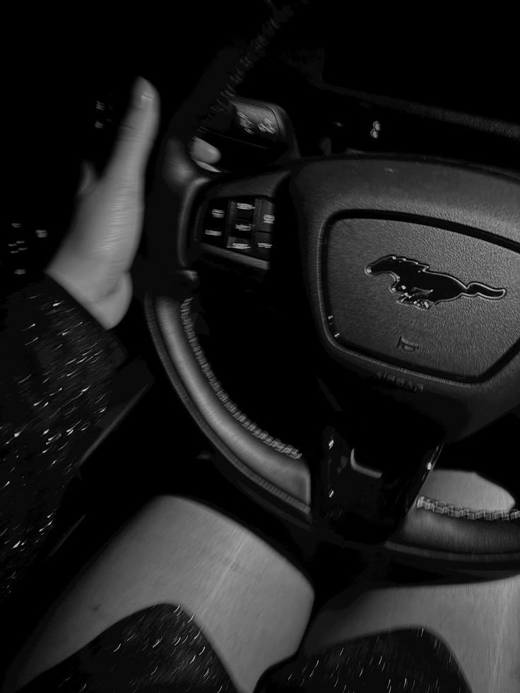 the interior of a car is shown in this black and white photo, with someone's feet on the steering wheel