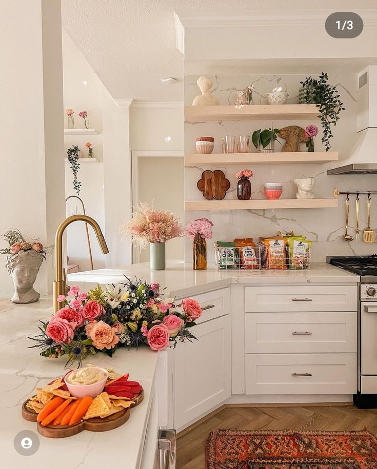 a kitchen filled with lots of white cabinets and counter top next to a stove top oven