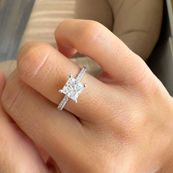 a woman's hand with a diamond ring on it