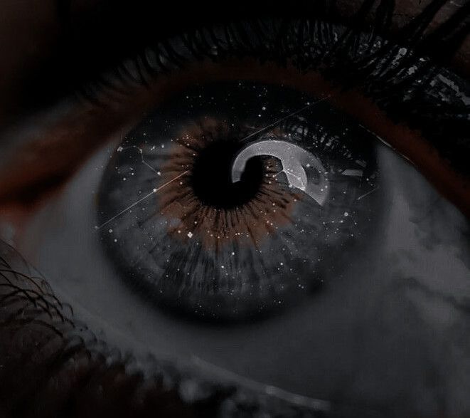 an extreme close up shot of the iris of a person's eye with stars in the background