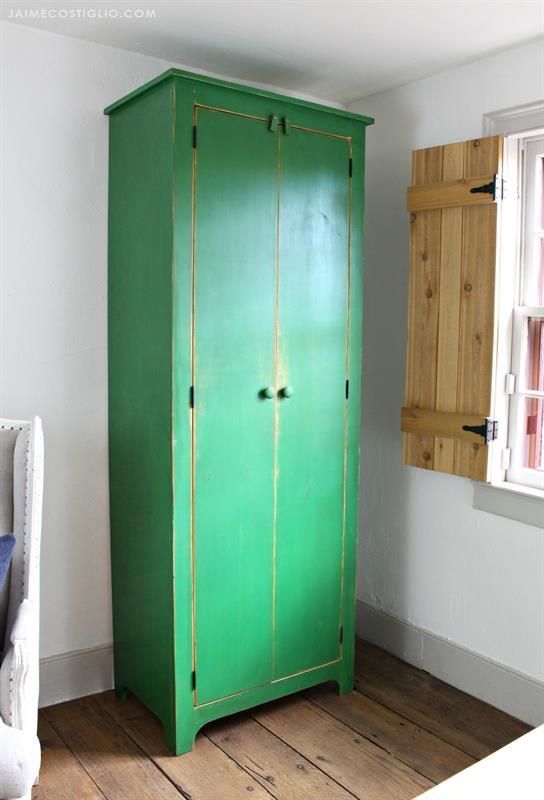 a green cabinet sitting in the corner of a room