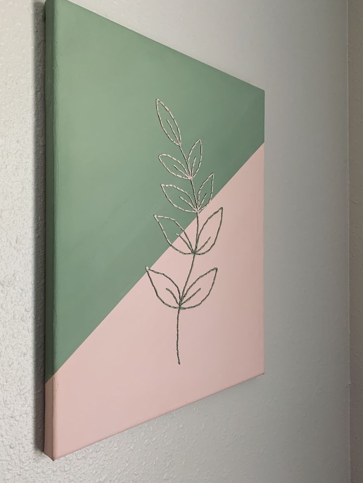 a painting hanging on the wall with a plant drawn on it's back side