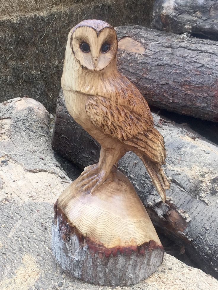 an owl statue sitting on top of a tree stump