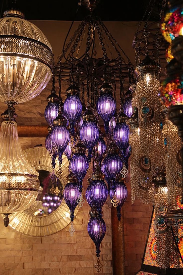 a bunch of chandeliers hanging from the ceiling in a room filled with lights