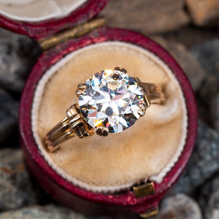 an engagement ring in a velvet box with stones around it and the inside is empty