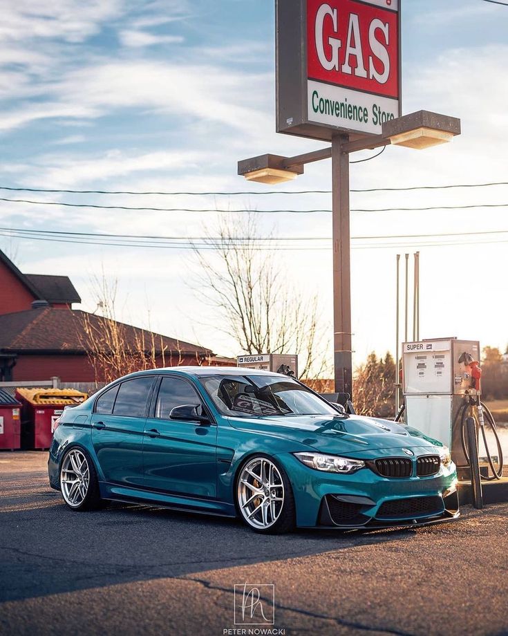 a blue car parked in front of a gas station