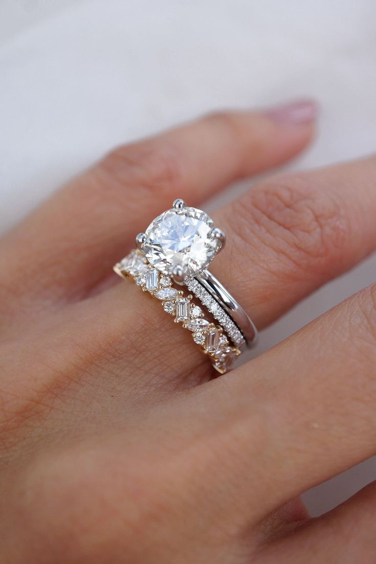 a woman's hand with a wedding ring and engagement band on her left hand