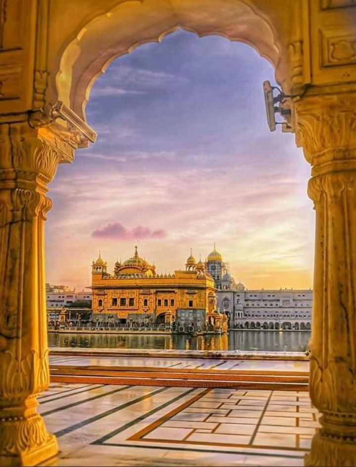 the golden building is surrounded by pillars and arches, as seen through an open doorway