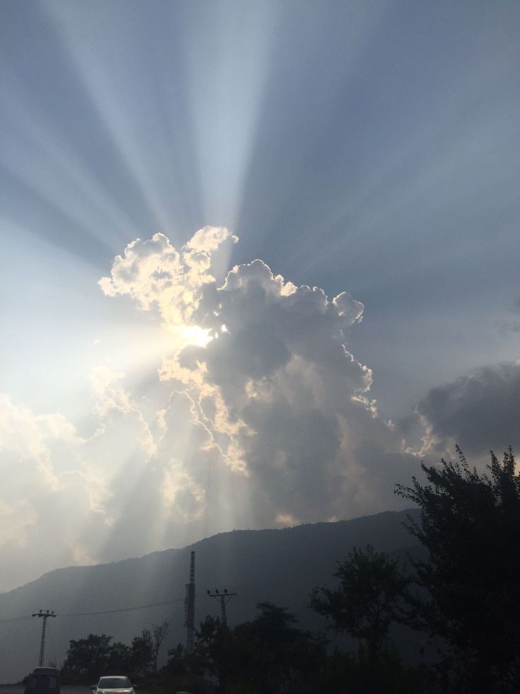 the sun shines brightly through clouds over mountains