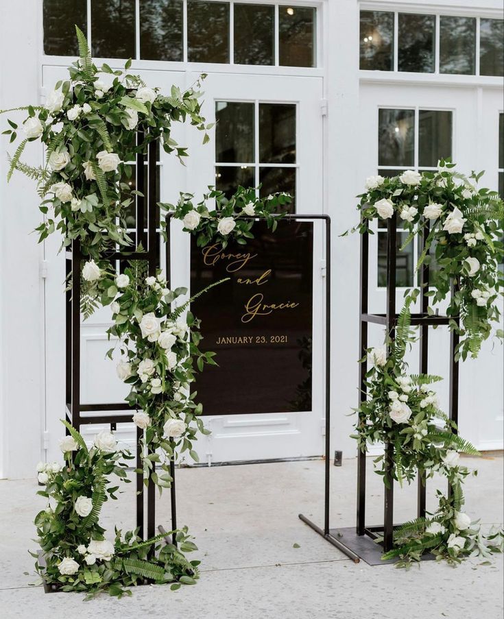 an outdoor ceremony with white flowers and greenery