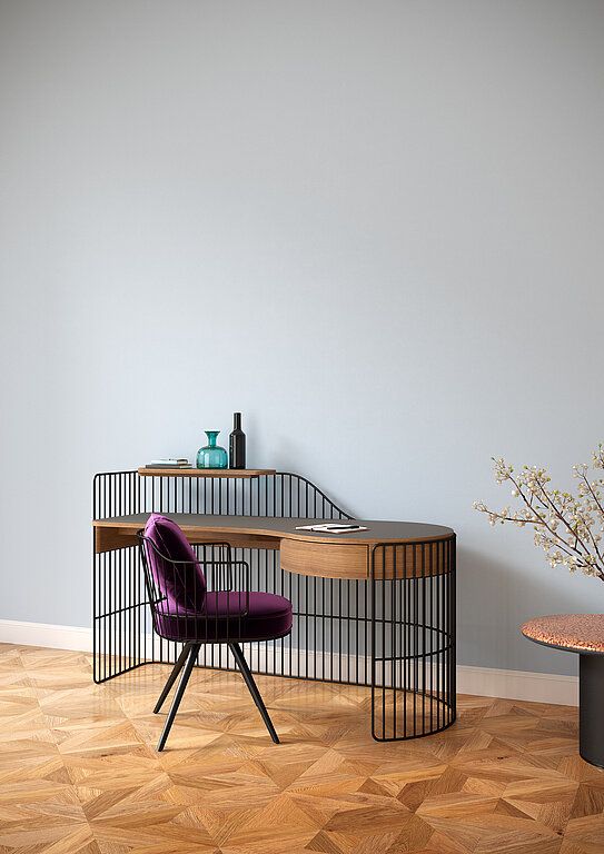 a purple chair sitting in front of a desk with a plant on top of it