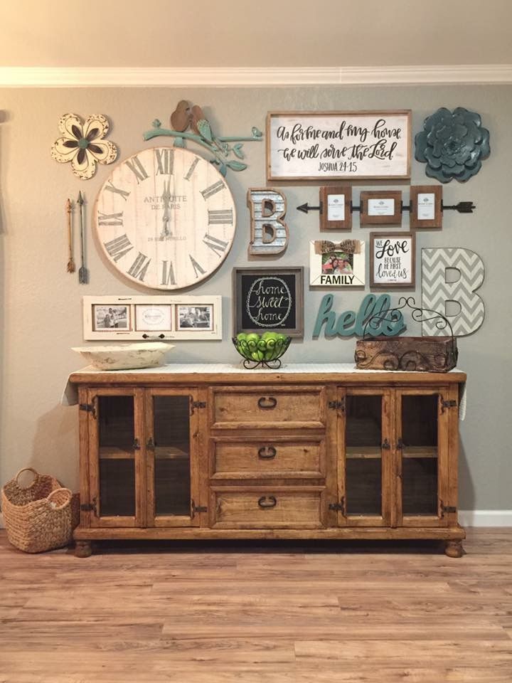 a living room with a large clock and pictures on the wall next to a wooden cabinet