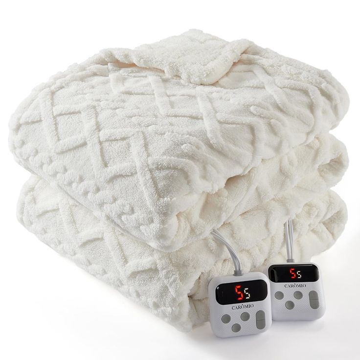 two alarm clocks sitting on top of a pile of white blankets with the numbers twenty and thirty