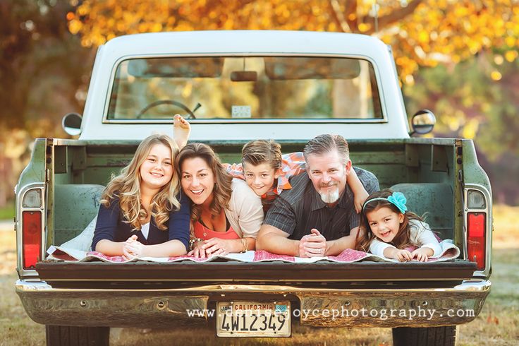 a family sitting in the back of a pick up truck